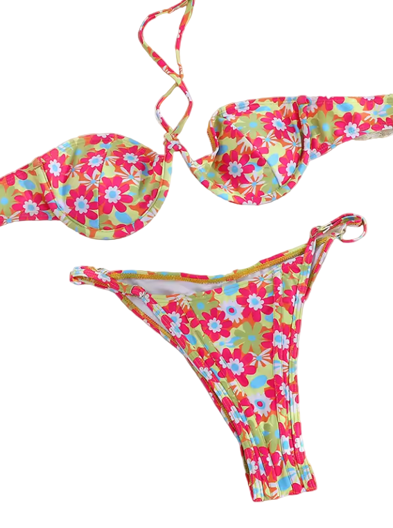 Flat lay of the Coastal Bloom Bikini in vibrant floral print, including adjustable bikini top and tie-side bottoms styled with beach accessories.